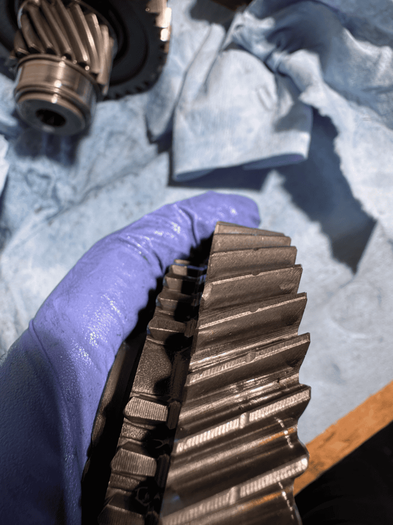 Worn vs new synchronizer ring comparison showing dog-teeth rounding and friction surface degradation
