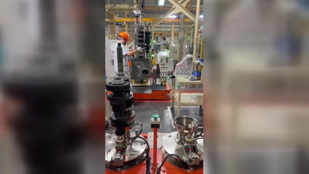 Operator assembling a gear cluster at a transmission assembly station